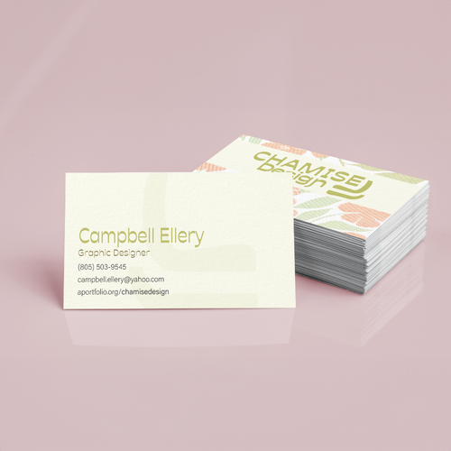 A stack of cream business cards on a dusty pink surface, with pale green lettering and pastel botanical shapes.