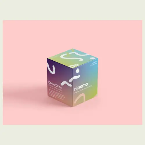 DecorOhm soy wax candle box with a purple, blue, green and yellow gradient, white organic shapes and Nipomo lettering, on a pink background.