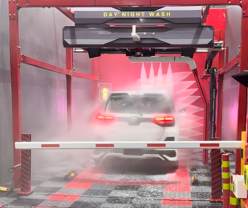 Touchless jets washing a car in a dark wash bay