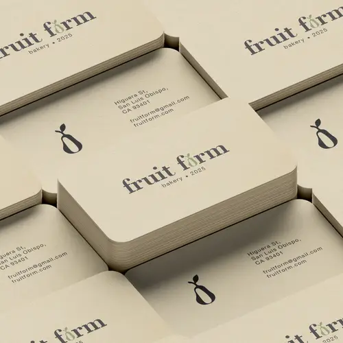 Stacks of cream business cards bearing the Fruit Firm wordmark and a small stylized fruit emblem.