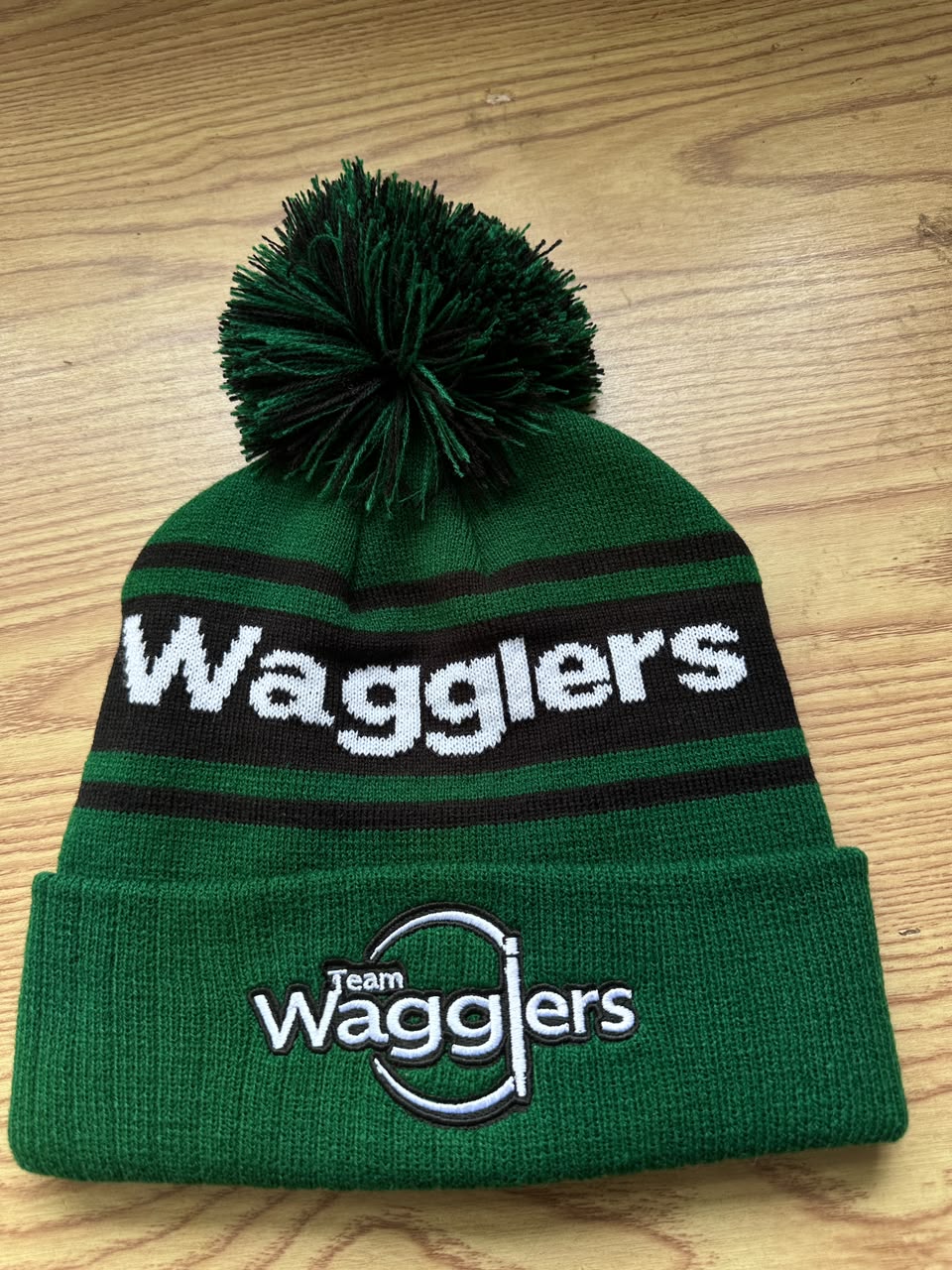 Custom green Team Wagglers bobble hat with embroidered Team Wagglers logo