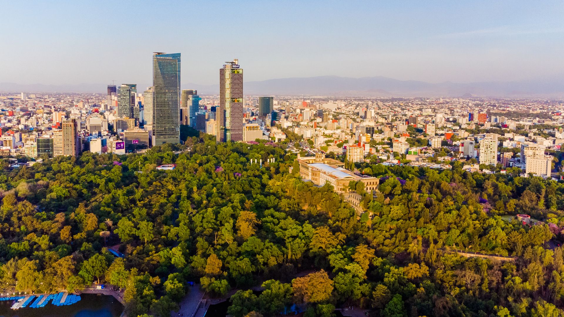 Aerial view of Chapultepec Park and the skyline of Mexico City at sunset