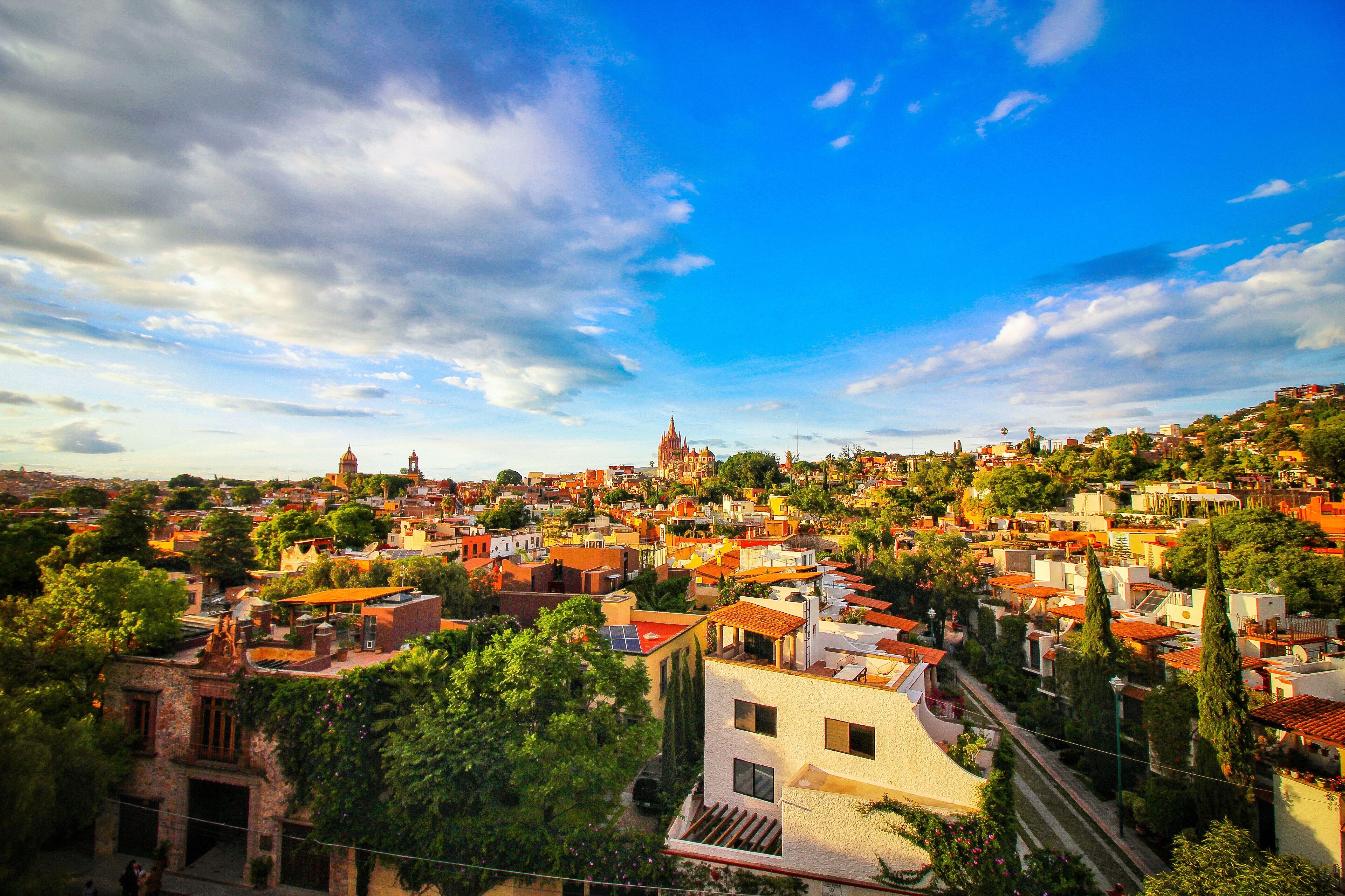 Elevated panoramic view of the colorful San Miguel de Allende cityscape under a bright blue sky