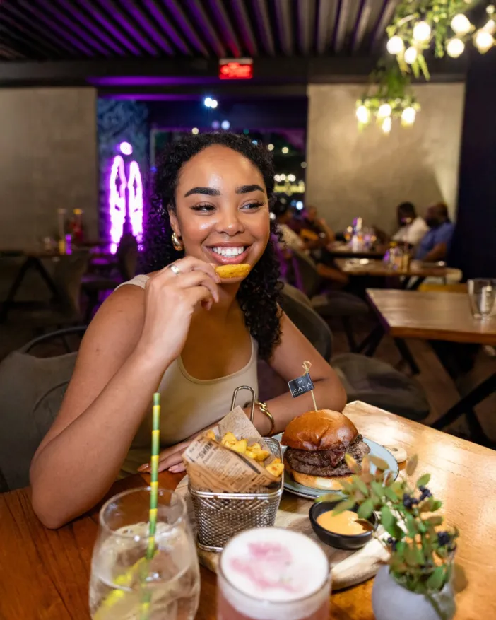 Smiling Guest Enjoying an Urban Burger at Kaya 91