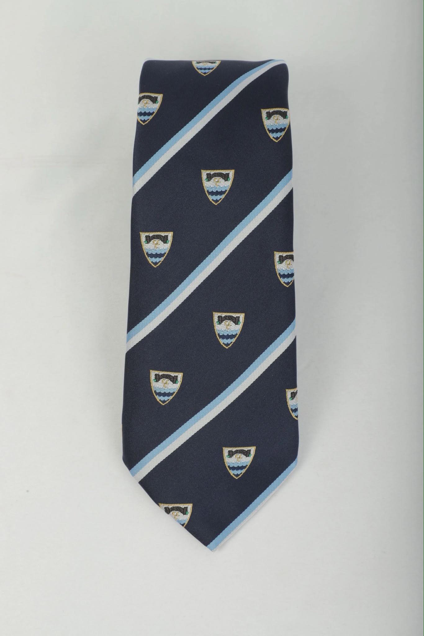 Navy and pale blue striped club tie with repeating heraldic shield crest