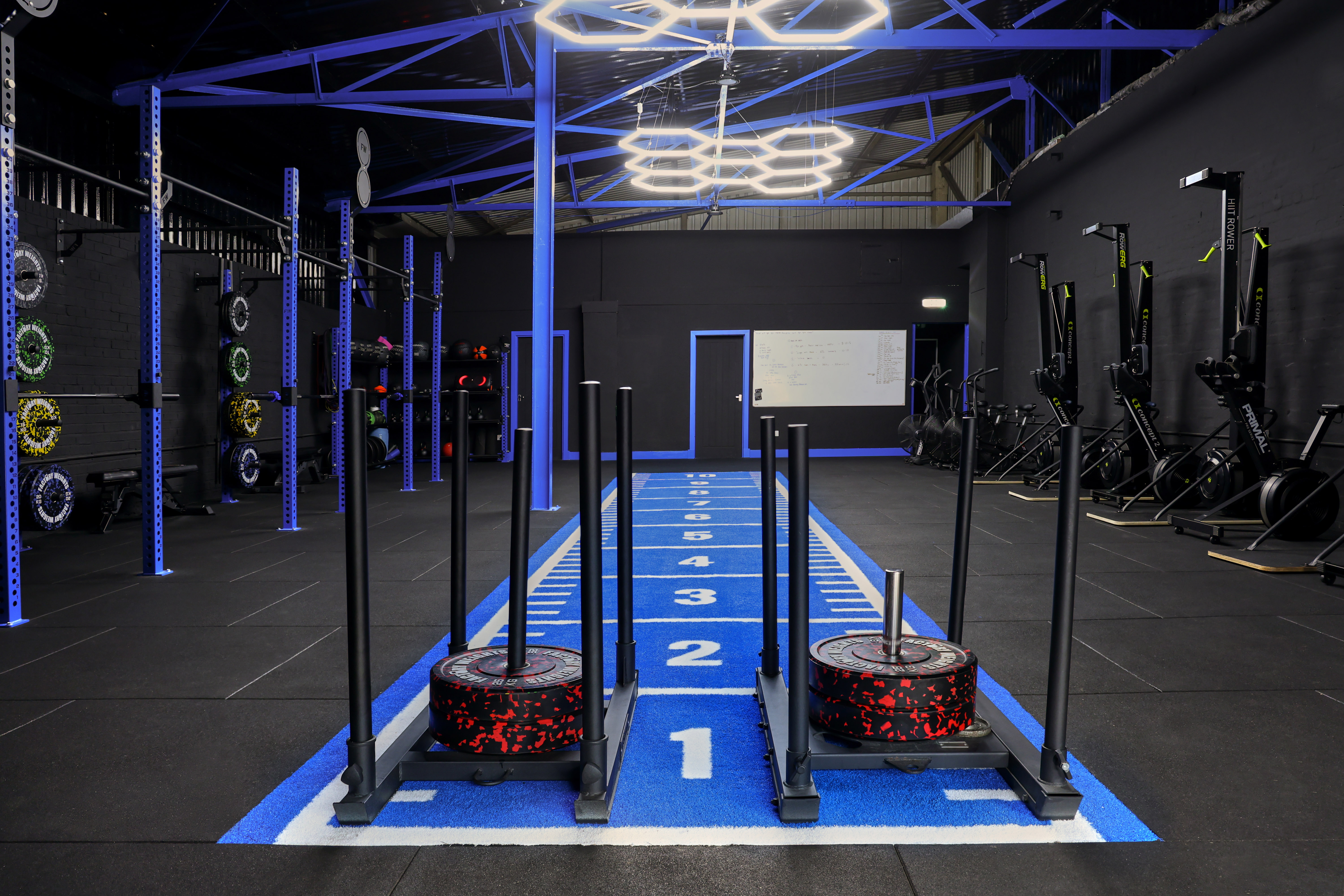 Factory Weights completed gym fit-out with blue turf track and sled push equipment