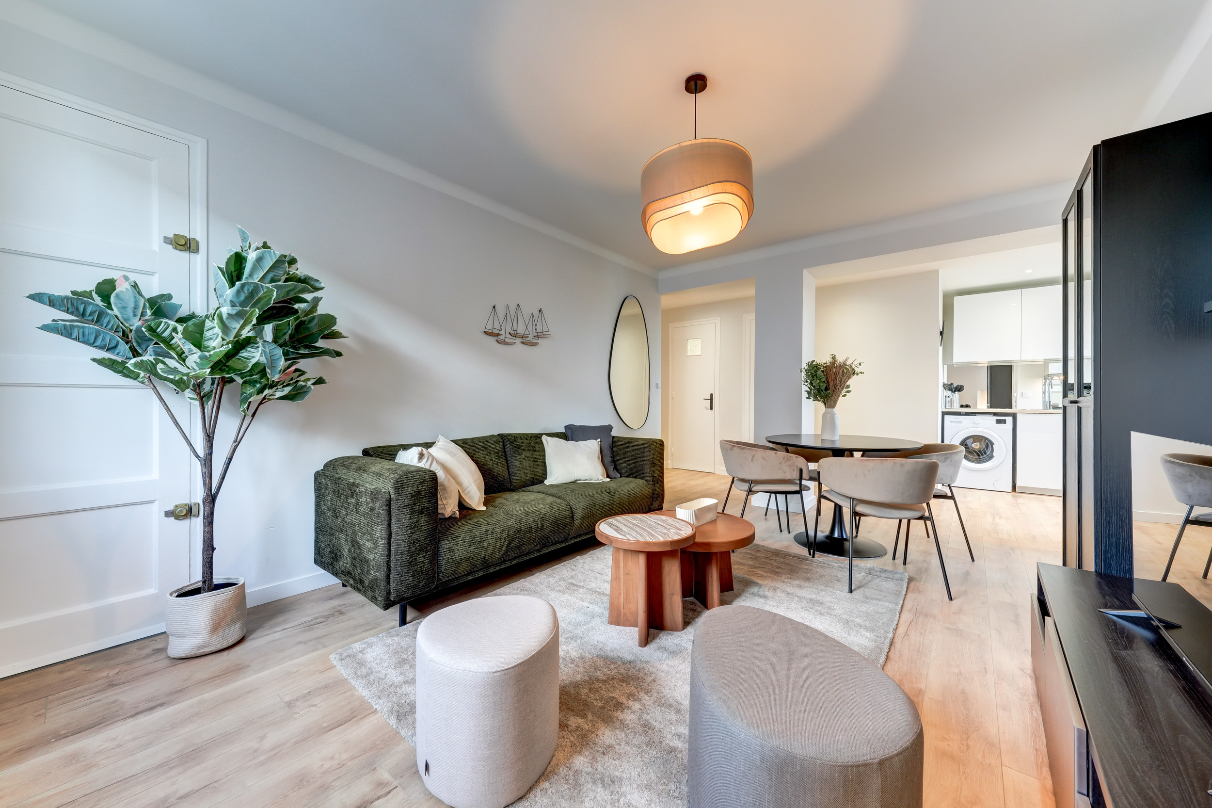 Salon moderne avec canapé vert et espace repas — pôle Investissement