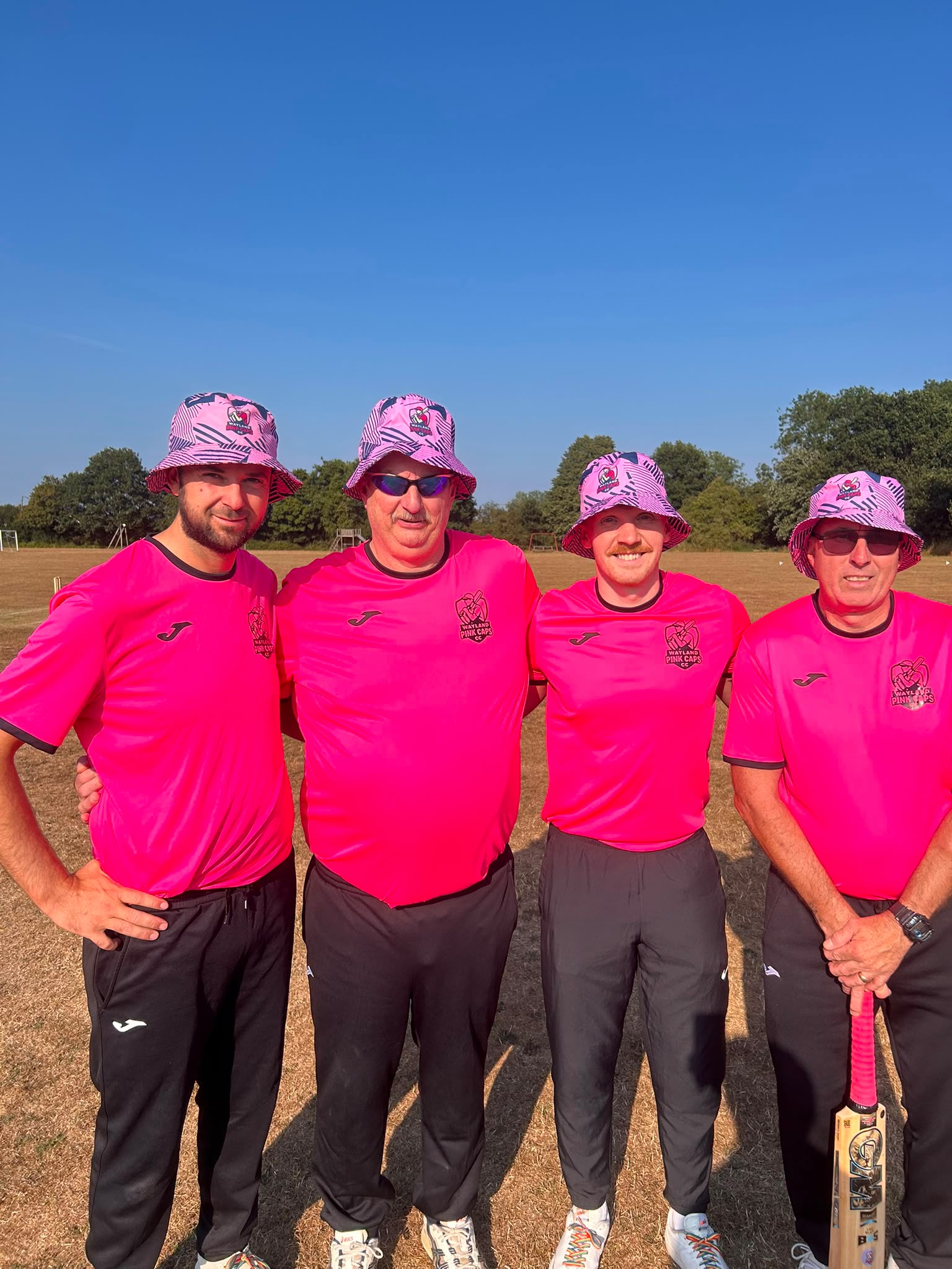 Wayland Pink Caps first team in pink kit and matching baggy hats on the field