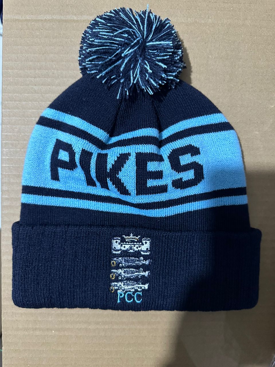 PRKCES custom navy and light blue bobble hat with castle PCC embroidered badge