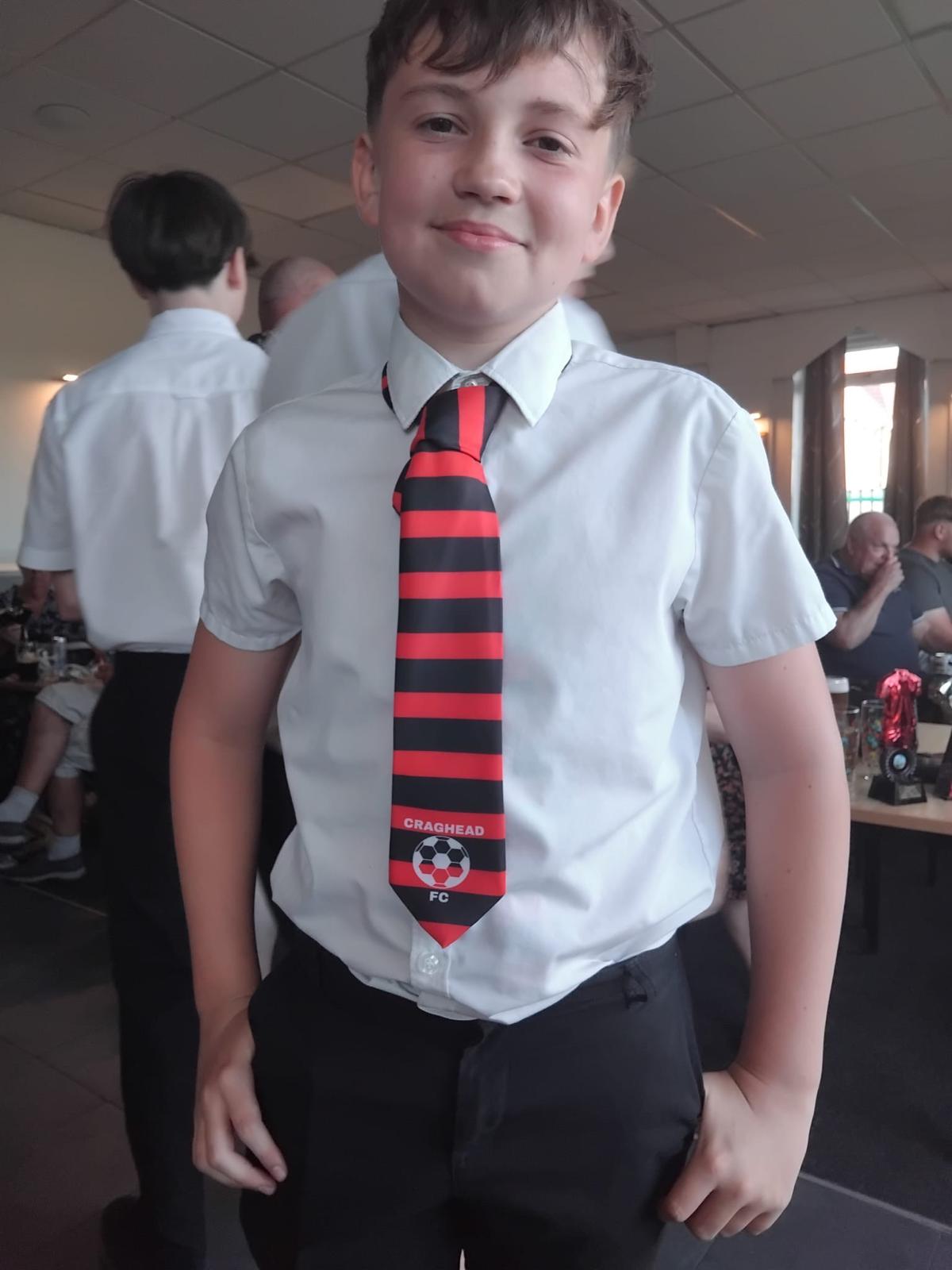 Craghead FC junior player wearing red and black striped club tie