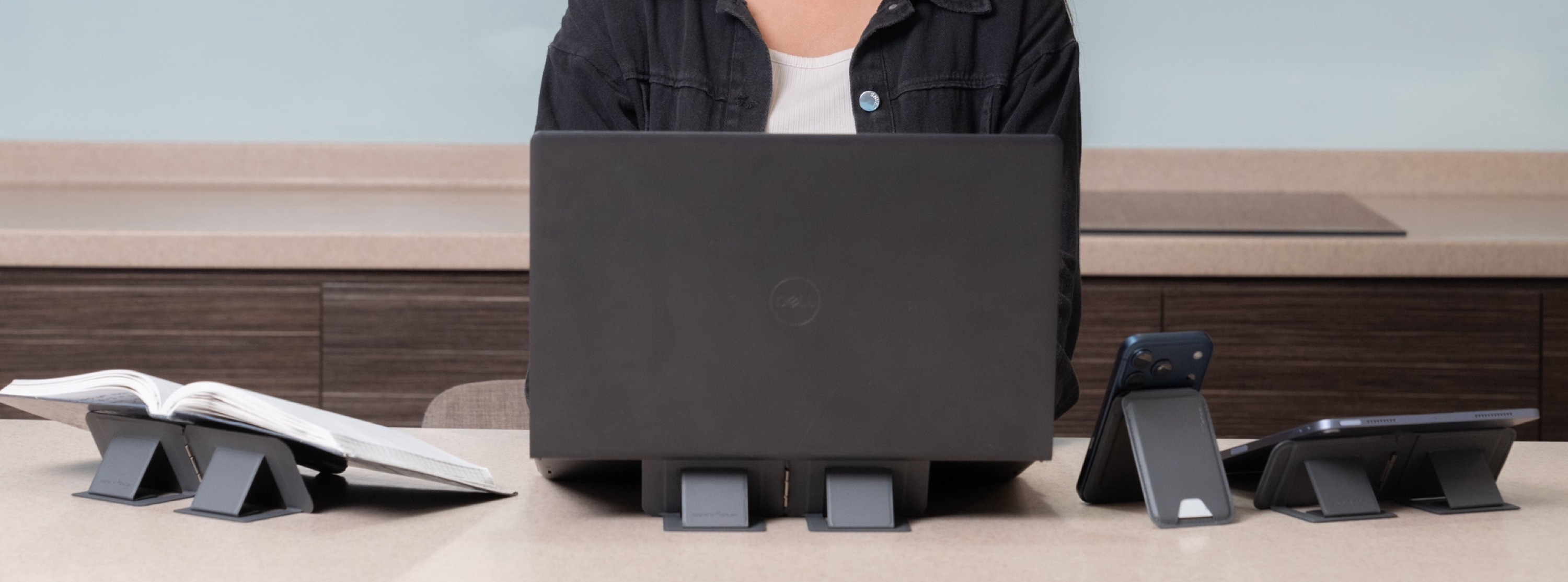 MagShift holding a book, laptop, phone, and tablet on a desk — showcasing seven functions at once