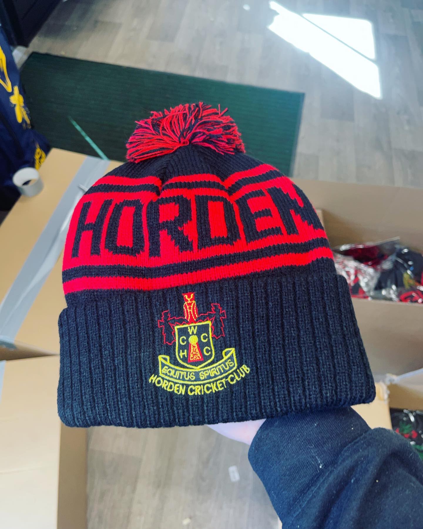 Horden Cricket Club custom navy and red bobble hat with HORDEN CRICKET CLUB knitted band and embroidered EQUITUS SPIRITUS shield crest
