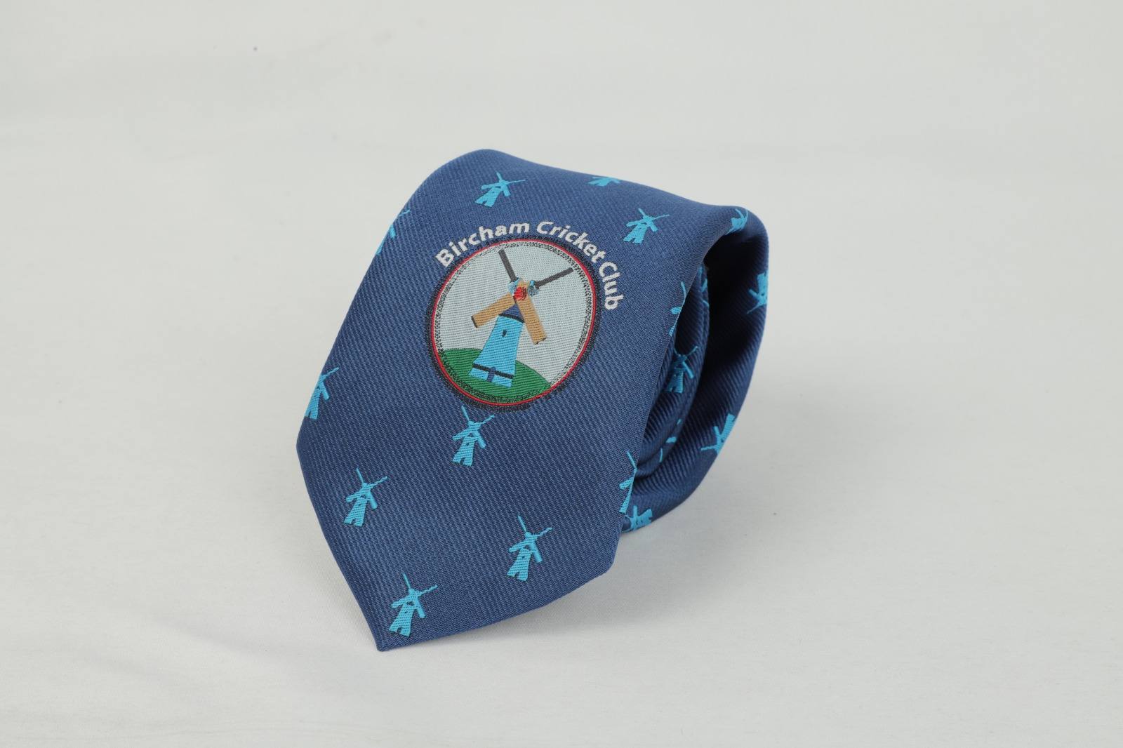 Custom navy tie with turquoise windmill pattern and Bircham Cricket Club badge