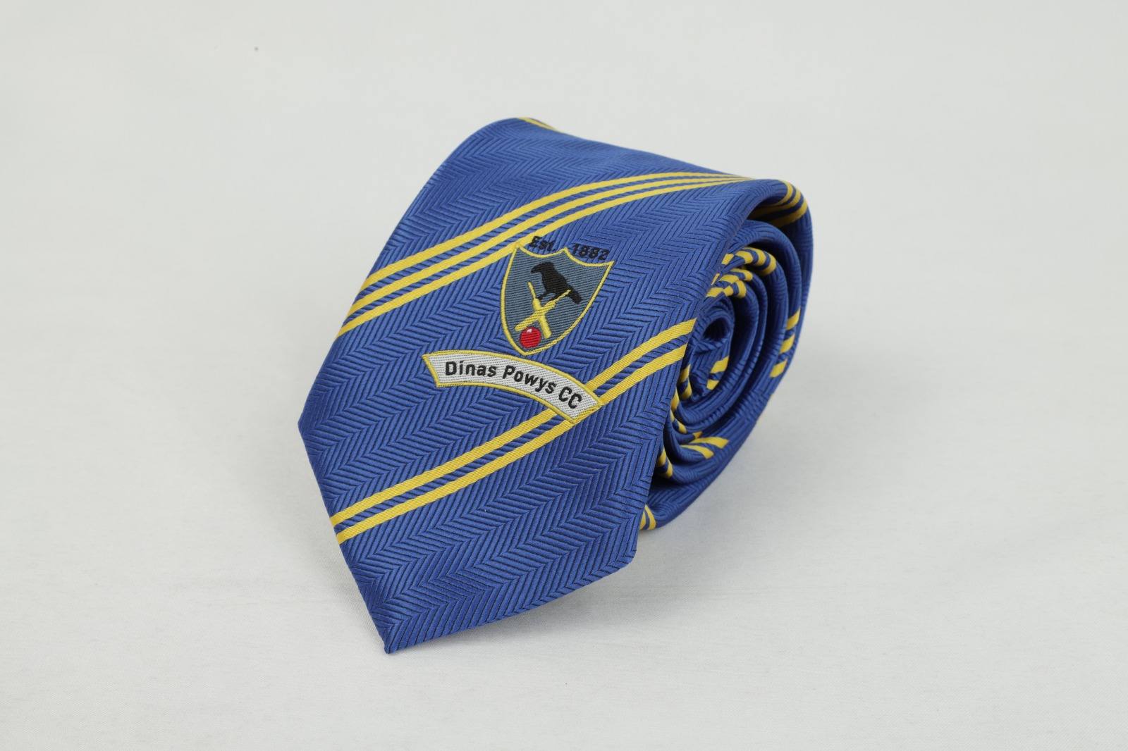 Custom blue herringbone tie with yellow stripes and Dinas Powys Cricket Club badge