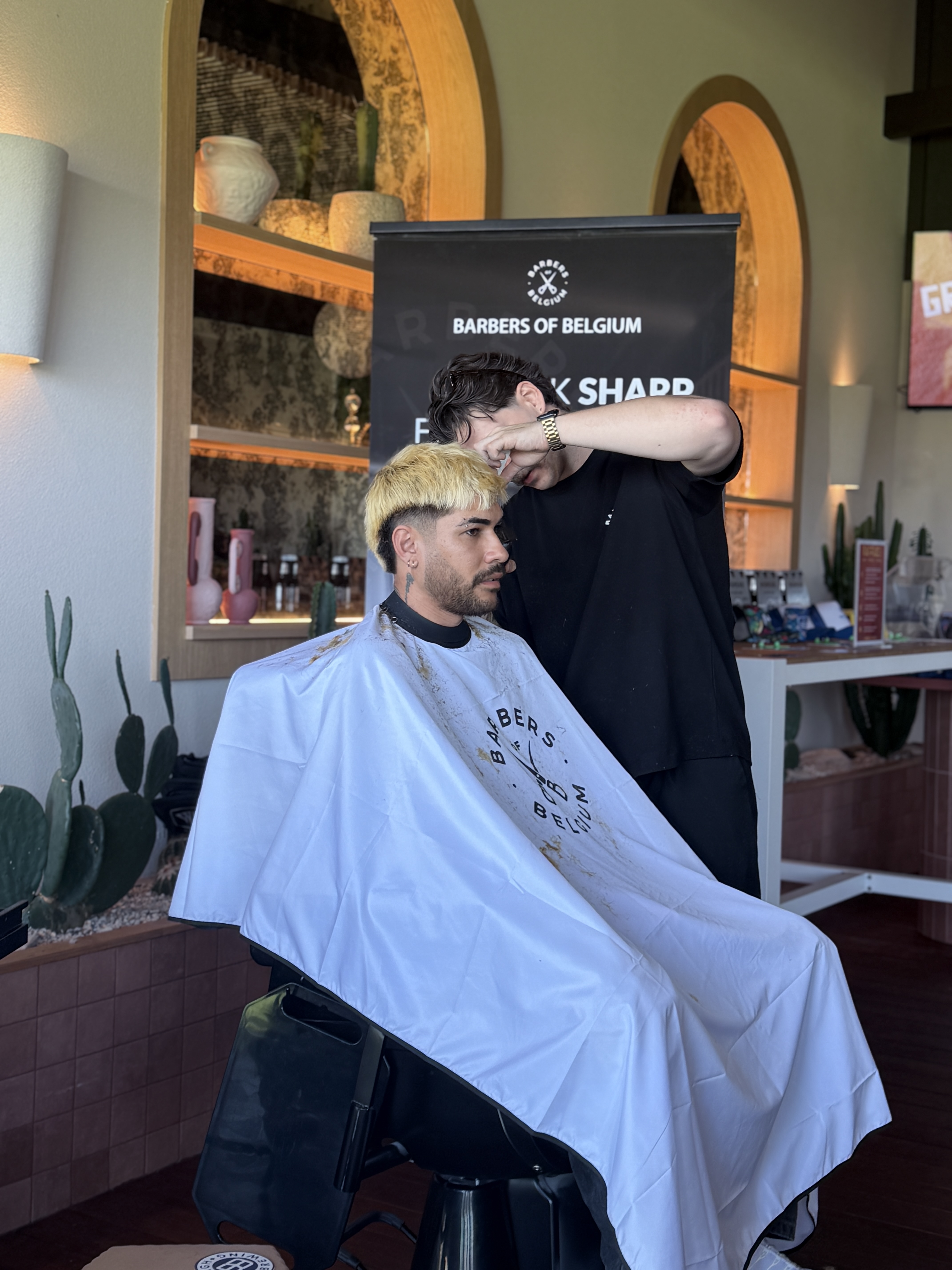Premium grooming setup with branded Barbers of Belgium backdrop at a corporate event